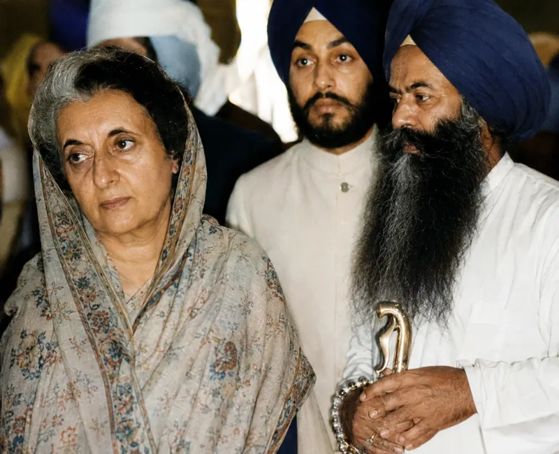 Standing beside Prime Minister Indira Gandhi at an indoor gathering.